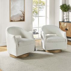 two white chairs sitting on top of a rug in a living room next to a window