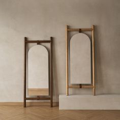 two mirrors sitting next to each other on top of a wooden floor