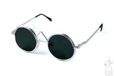 Round silver metal frame sunglasses with polarized lenses John Lennon style. Frame has an unusual bridge. Lenses are flat. Lenses have UV400 sun protection. UVA400 ，UVB400 Suit most faces. Dimensions are as follows: Frame across at temples measures 130mm Lens diameter is 43mm Temples are 113mm till curving point Bridge is 18mm Trendy Silver Round Frame Sunglasses, Retro Silver Metal Sunglasses, Retro Silver Sunglasses With Metal Frame, Vintage Silver Sunglasses For Summer, John Lennon Style, Sunglasses Silver, Silver Sunglasses, Steampunk Sunglasses, Sunglasses Style