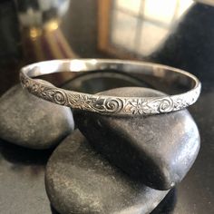 This listing is for one thick Sterling Silver floral Bangle Bracelet. This beautiful pattern bangle is 5.13mm wide and 1.78mm thick and is sure to be a unique addition to your favorite stacking bangle bracelets! This beautiful bangle is lovely and super strong. Stamped. All bangles are soldered, hammered, tumbled for hours and hand-polished just for you! My bangle sizes are available in the following sizes: Small - 2 1/4 inch diameter - Petite Adult 7 inch circumference Medium - 2 1/2 inch diame Elegant Stamped Cuff Bracelet In Bangle Style, Elegant Stamped Cuff Bracelet Bangle, Ornate Stamped Bangle Bracelet, Elegant Etched Bangle Bracelet, Etched Bangle Bracelets For Wedding, Elegant Round Stamped Bracelets, Ornate Round Etched Bracelets, Elegant Stamped Bracelet, Ornate Adjustable Sterling Silver Bangle