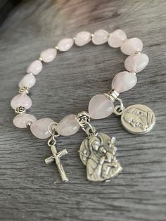 Item details Handmade Materials Gemstone: Heart-shaped Rose Quartz, Our Lady of Perpetual Help Medal, Padre Pio Medal, small ornate cross, Durable high quality stretch cord Rosary Bracelet for Women Stretch Bracelets, Our Lady of Perpetual Help, Padre Pio and small cross  Bracelet size is 7". Please message seller if requesting for a different size.  This will be a great gift for confirmation!  A unique and beautiful personalized rosary bracelet!  It will make a perfect religious themed gift or inspiration for yourself. The beads used on every piece are handpicked. We make sure that each bracelet includes a range of the natural colors found in the stone It is not guaranteed to look exactly the same as shown in pictures but we promise it will be just as pretty! To find your perfect bracelet Our Lady Of Perpetual Help, Lady Of Perpetual Help, Personalized Rosary, Rosary Bracelet, Rosary Necklace, Women Rising, White Howlite, Small Crosses, Cross Bracelet