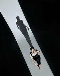 a woman standing in the middle of a long shadow