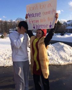 two people dressed up as hotdogs and one is holding a sign that says don't be a meme