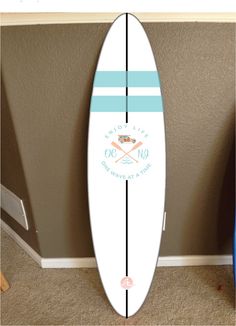 a white surfboard sitting on top of a carpeted floor next to a wall