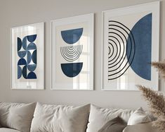 three blue and white art prints hanging on the wall above a couch in a living room