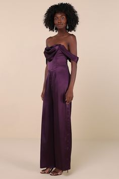 Arrive looking oh-so-glamorous in the Lulus Unbelievable Aura Dark Purple Satin Off-the-Shoulder Jumpsuit! Glossy woven satin shapes this luxe jumpsuit with an off-the-shoulder neckline and a cowl-front, bustier-style bodice with supportive boning and pleated sleeves. Basque-inspired waist sits atop wide pant legs that finish at full-length hems. Hidden no slip-strips and hidden zipper/clasp at back. Fit: This garment fits true to size. Length: Floor length. Size medium measures 53.5" from top t Elegant Fitted Satin Strapless Jumpsuit, Fitted Satin Strapless Jumpsuit For Night Out, Fitted Satin Jumpsuit And Romper For Party, Evening Strapless Satin Jumpsuit, Elegant Strapless Jumpsuit For Gala, Elegant Strapless Jumpsuits And Rompers For Gala, Elegant Satin Jumpsuits And Rompers For Party, Fitted Satin Jumpsuits And Rompers For Date Night, Formal Off-shoulder Jumpsuits And Rompers