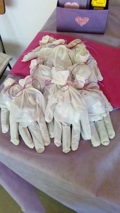 several pairs of white gloves sitting on top of a table