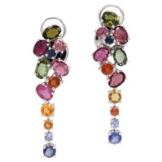 EARRINGS 18K White Gold Weight 11.08 GMS  Tourmaline Sapphires - 24-5.85 Cts Indulge in elegance with our exquisite floral collection earrings. Crafted with precision, these captivating dangle earrings boast 5.85 carats of multicolored gemstones set in luxurious 18K white gold. The ensemble features a harmonious blend of Tanzanites, Yellow Sapphires, Pink Sapphires, Blue Sapphires, and Multicolored Tourmalines, creating a stunning symphony of colors and brilliance. Each gemstone is carefully cho Multicolor Palette, Floral Motives, Ear Drops, Gold Dangle Earrings, Floral Collection, Cocktail Parties, Deco Floral, Color Tones, Vibrant Green