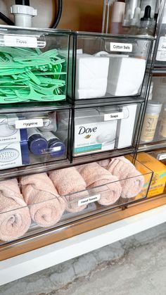 clear bins filled with towels and other items on the shelf in front of it