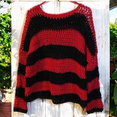 a red and black sweater hanging on a clothes line