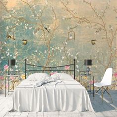 a bed sitting in front of a wall with flowers on it