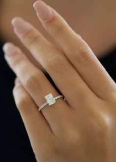 a woman's hand with a diamond ring on it