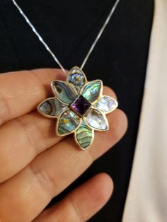 "Super HIGH QUALITY Everything! All Sterling Silver in a flower shape; Petals are all made of inlaid ABALONE (specifically from New Zealand and called Paua Shell - very intense colors); Center is a 7x7mm Sugarloaf cut AMETHYST. **THIS PIECE IS BOTH A PENDANT AND A PIN OR BROOCH** Measures 1.25\" each direction. I am including an 18\" Sterling Silver chain too. Hallmarked SAJEN 925 By the renowned designers RICHARD & MARIANNA JACOBS, the OFFERINGS line by SAJEN. Made in Bali. Contact me with Sterling Silver Jewelry With Purple Flower Charm, Purple Sterling Silver Flower-shaped Jewelry, Purple Sterling Silver Jewelry With Flower Charm, Purple Jewelry With Flower Charm For Mother's Day, Purple Flower Jewelry For Mother's Day, Purple Flower-shaped Sterling Silver Jewelry, Amethyst Flower-shaped Jewelry Gift, Purple Flower Shaped Gemstone Jewelry, Purple Flower-shaped Nickel-free Jewelry