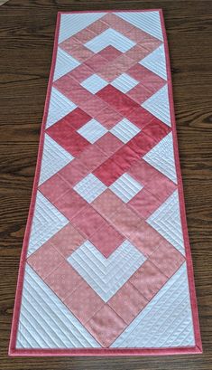 a pink and white quilted table runner