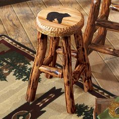 a wooden stool with a black bear on it's back and footrests