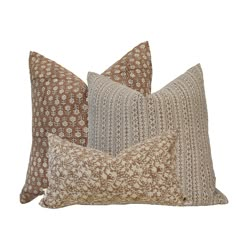 three brown and white pillows on a white background