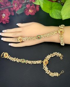 This is an Adjustable elegant gold finished ruby and Green  stones phool /  hath  panja / hath paan / bridal bracelet / Finger ring Bracelet combo .  This modern hath Phool is a light weight version of the traditional Hand piece with a single ring. This is a pair of hathphools. The length of the bracelet and the connection to Ring is given in one of the Pictures. Please take a look. Let us know if you have any questions on the item before ordering so you can shop confidently. Thanks Hand Harness, Finger Bracelets, Bridal Bracelet, Wedding Jewelry Bracelets, Chain Ring, Wedding Bracelet, Ring Bracelet, Pearl Bracelet, Antique Gold