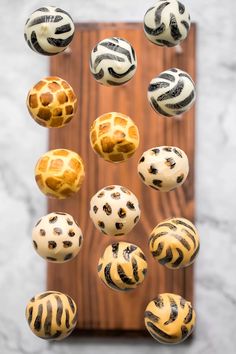 an assortment of different types of cakes on a wooden platter with zebra print icing