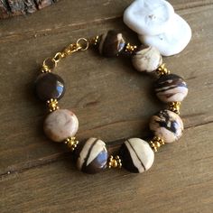 Fall bracelet brown Jasper natural stone coin bracelet fashion gold bracelet boho stone bracelet gift unique jewelry bracelet for women 6 Length: 6.5 inches approx Who doesn't love a beautiful bracelet. I search the world over for some of the best stones and beads and also create my own so you can jazz up that most forgotten wrist. Treat yourself or someone special to something unique. This bracelet has 14mm natural stone painted Arizona Jasper beads, Bali beads, gold plated findings, lobster cl Earthy Gold Bracelets With Natural Stones, Brown Round Gemstone Beads Jewelry, Brown Natural Stones Round Jewelry, Brown Round Bracelets For Jewelry Making, Handmade Brown Bracelet Jewelry, Handmade Brown Bracelet, Bohemian Round Brown Jewelry, Bohemian Brown Round Jewelry, Earthy Brown Round Jewelry