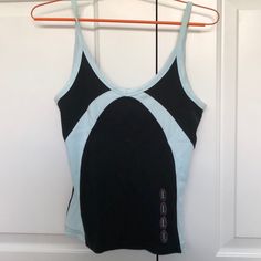 a women's black and blue tank top hanging on a hanger in front of a door