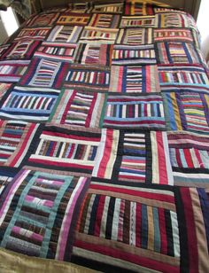 a bed with a colorful quilt on top of it