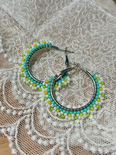 Hand beaded hoop earrings.  Hinge closure. Hoop measures approximately 1" wide. Summer Small Hoop Jewelry With Dangling Beads, Small Hoop Earrings With Dangling Beads For Summer, Summer Hoop Earrings With Dangling Beads, Small Hoop Summer Jewelry, Summer Small Hoop Earrings With Dangling Beads, Beaded Hoop Festival Jewelry, Beaded Hoop Jewelry For Festivals, Nickel-free Small Hoop Beaded Earrings For Summer, Green Beaded Hoop Earrings For Summer