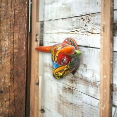 a colorful bull's head mounted to the side of a wooden wall