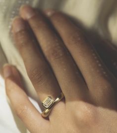 a woman's hand with a gold ring on it and a diamond in the middle