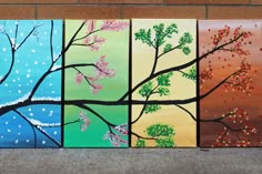 four paintings of trees painted on canvases in different colors and sizes, each with their own tree branch