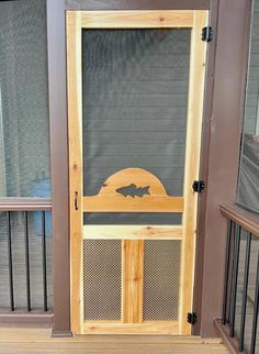 a wooden door with an iron screen on the front and side panels that have fish silhouettes painted on them