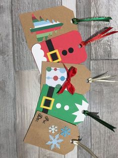 christmas gift tags made out of cardboard with scissors and paper on the top, sitting on a wood floor