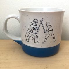 a coffee cup with two people playing baseball on it and one holding a bat in the other's hand