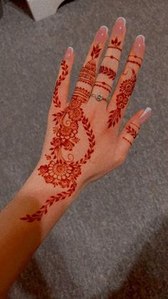 a woman's hand with henna tattoos on it