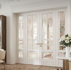 an elegant dining room with white walls and glass doors