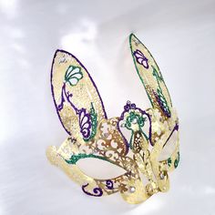 This bunny style Masquerade Mask complements any Mardi Gras themed attire. Gold, purple and green vibrant colors to complete your Mardi Gras look no matter what you wear! I N C L U D E D Available for purchase individually or as a couple's set. Masks come with matching double sided satin ribbons attached. S H I P P I N G - Processed same day or within 24 hours. 1-2 day guaranteed delivery services offered, add items to cart and click on shipping tab for rates. Pls leave a check out note with you Metal Mask, Bunny Mask, Mask Style, Children's Mask, Satin Ribbons, Masks Masquerade, Costume Mask, Masquerade Mask, Sewing Leather