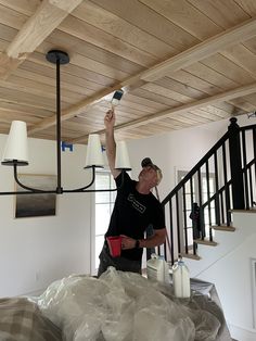 a man is painting the ceiling in his house