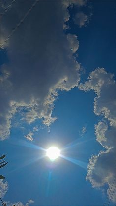 the sun shines brightly in front of some clouds and power lines on a sunny day