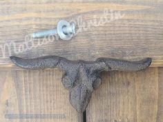 a metal hook on the side of a wooden door with an animal's head