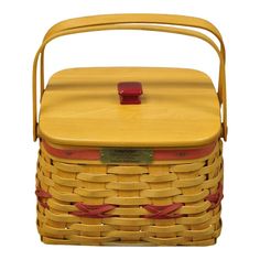 a yellow basket with red handles on a white background is seen in this image, it's made from wood and woven material