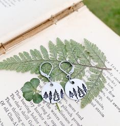 Rustic Tree Earrings, Nature Tree Dangle Earrings, Hypoallergenic Ear Jewelry, Forest Jewelry, Nature Lover Gift, Hiker Gifts, Outdoors Gift Rustic tree earrings!! Great gift idea for nature lovers, hikers, campers, forest rangers, mountain lovers and much more!! These earrings are made with round silver aluminum charms metal stamped with 3 different tree types (4 total trees) on each one. They are attached to stainless steel lever back ear wires.  These earrings are extremely lightweight and ar Nature-inspired Hoop Earrings As Gift, Nature-inspired Round Hoop Earrings For Gift, Adjustable Personalized Earrings As Gift, Personalized Adjustable Earrings For Gift, Nature-inspired Jewelry Ear Wire For Gift, Nature-inspired Dangle Hoop Earrings As Gift, Nature-inspired Dangle Hoop Earrings For Gift, Nature-inspired Dangle Hoop Earrings, Nature-inspired Everyday Dangle Jewelry