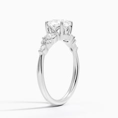 Cushion Cut Nadia Three Stone Engagement Engagement Ring - Platinum. This three stone ring features a dazzling cluster of round and marquise-shaped diamonds that rest upon the shoulders of the gently tapered band. The center gem is held by four claw prongs as it sits upon a slightly open gallery (2/5 total carat weight). Anniversary Marquise Lab Grown Diamond Ring, Anniversary Ring With Marquise Cut Lab Grown Diamond, Anniversary Marquise Cut Lab Grown Diamond Ring, Anniversary Lab Grown Diamond Ring, Marquise Cut, Anniversary Wedding Ring With Marquise Cut Lab Grown Diamond, Silver Lab-grown Diamond Marquise Cut Ring, Promise Cluster Ring With Brilliant Marquise Cut, Promise Cluster Ring With Marquise And Brilliant Cut, Timeless Marquise Cut Diamond Ring