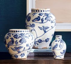 three blue and white vases sitting on top of a table