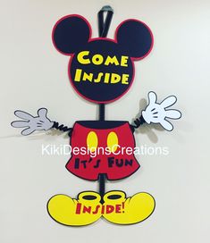 some kind of mickey mouse sign hanging on the wall with it's fun inside