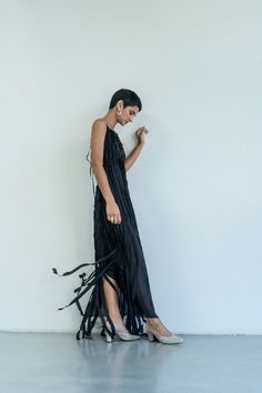 This enchanting Teatralna Black dress is a vision of grace, fashioned entirely from 100% silk. Its backless allure adds a hint of sensuality, while the dual layers of silk add depth and texture. The distinctive feature lies in the top layer, composed of vertical stripes that elegantly run longer than the bottom layer, creating a captivating play of length and movement. The arrangement of these strips imparts a unique, modern charm to the gown, making it a standout choice for those seeking a blen