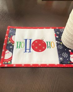 a place mat with the word ho ho on it and a christmas ornament