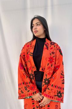 Step into bohemian elegance with this exquisite Orange hand dyed  duster jacket crafted from vintage Banjara fabric, tailored for women who appreciate unique fashion with a rich cultural heritage. Handcrafted by the nomadic Banjara tribe of North India, this one-of-a-kind jacket showcases their artisanal expertise and their fascinating lineage. Jacket Measurements: This longline cardigan jacket is ready to be dispatched in following measurements refer images for measurement guide Chest(pit to pit): 23 inches/ 59 cm Length 48 inches / 122 cm Shoulder: 18 inches/ 46 cm Sleeve: 22 inches/ 56 cm Fits - S/M/L Pls message me to get a custom jacket made as per your fit.  Special feature : Folk art embroidery motifs of Sun, Peacocks, Lion, Raas leela (Dance of divine love) Details:  Cotton 'bagru' Long Outerwear With Chikankari Embroidery, Fall Chikankari Embroidery Kurta, Traditional Spring Kimono Shawl, Bohemian Long Outerwear With Chikankari Embroidery, Long Winter Outerwear With Chikankari Embroidery, Traditional Shawl Kimono For Spring, Bohemian Cotton Shawl For Spring, Bohemian Kurta With Resham Embroidery For Fall, Bohemian Resham Embroidered Kurta For Fall