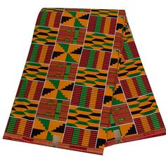 an orange, green and black african print fabric with geometric designs on the edges is folded in half