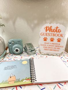 an open photo book sitting on top of a table next to a camera and other items