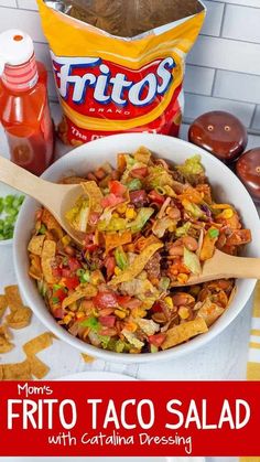 a white bowl filled with taco salad next to a bag of chips and ketchup