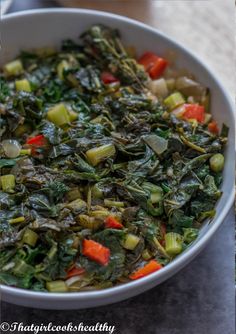 a white bowl filled with vegetables on top of a table